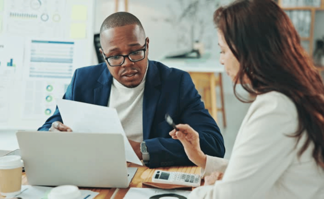 Man and woman in a meeting looking over a paper